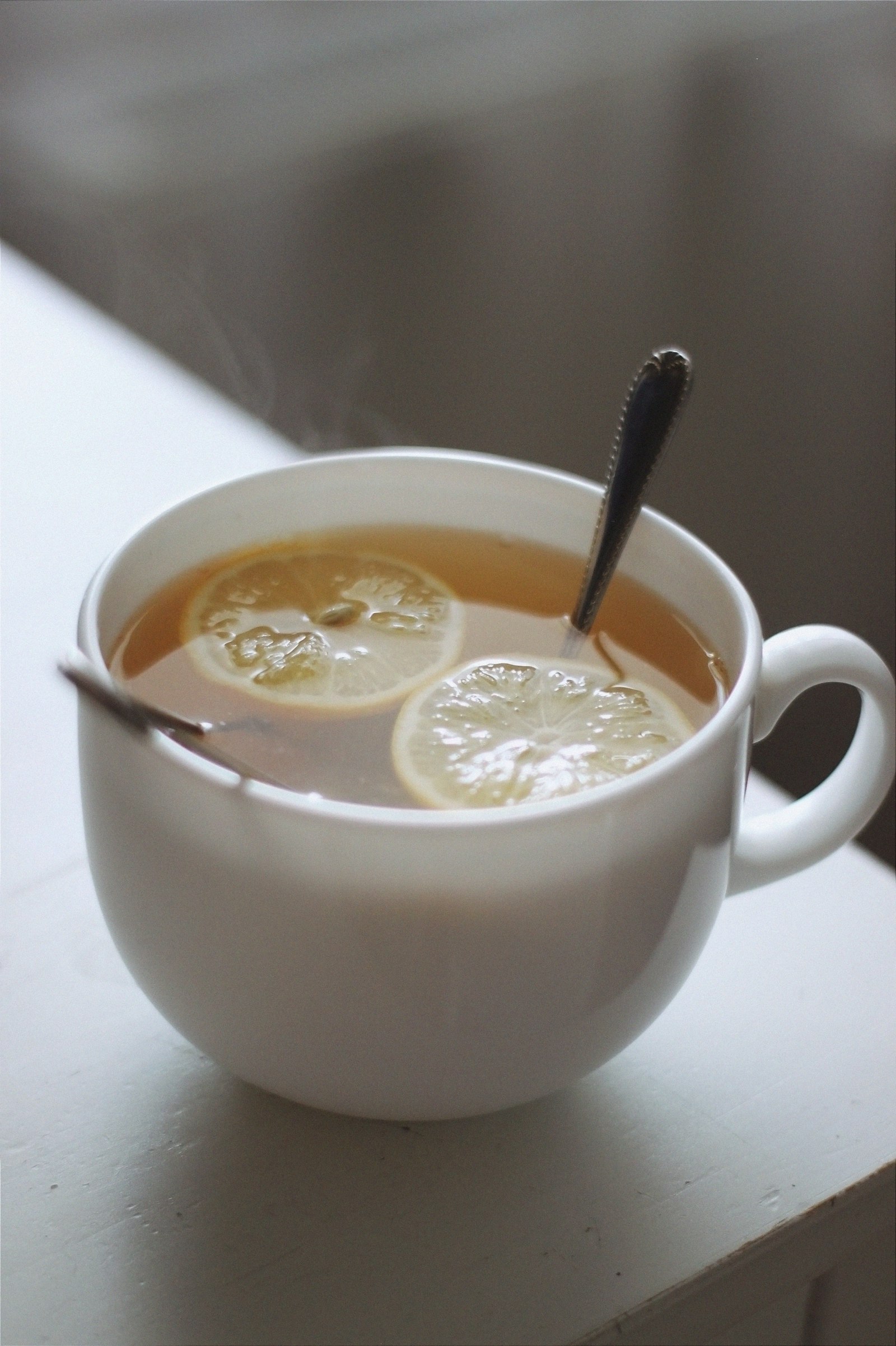 Taza cerámica blanca con té dorado caliente
